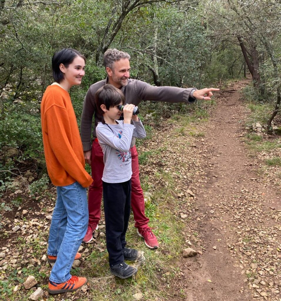 Adulte et enfants observant la nature avec des jumelles.