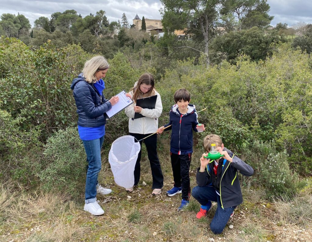 Groupe à la découverte des insectes équipé de fioles et filets.